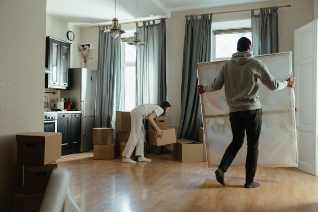 a-couple-moving-boxes-and-art-into-their-new-rental-property