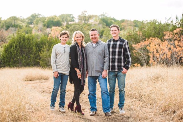 A family posing for a picture in the middle of a field.