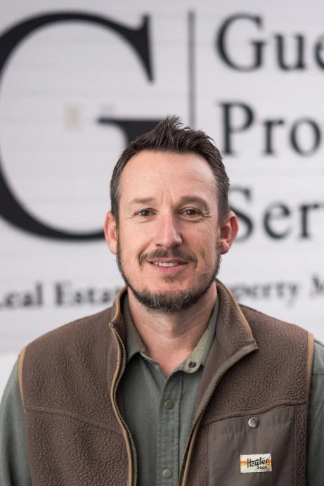 A man standing in front of a sign.